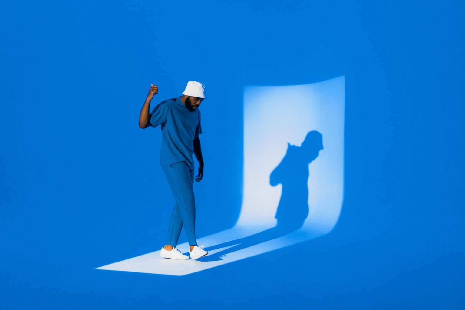 A man poses, casting a shadow.